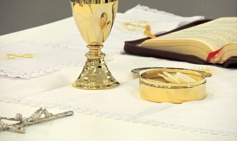 Eucharistiefeier: Weinkelch und Hostienschale auf dem Altar